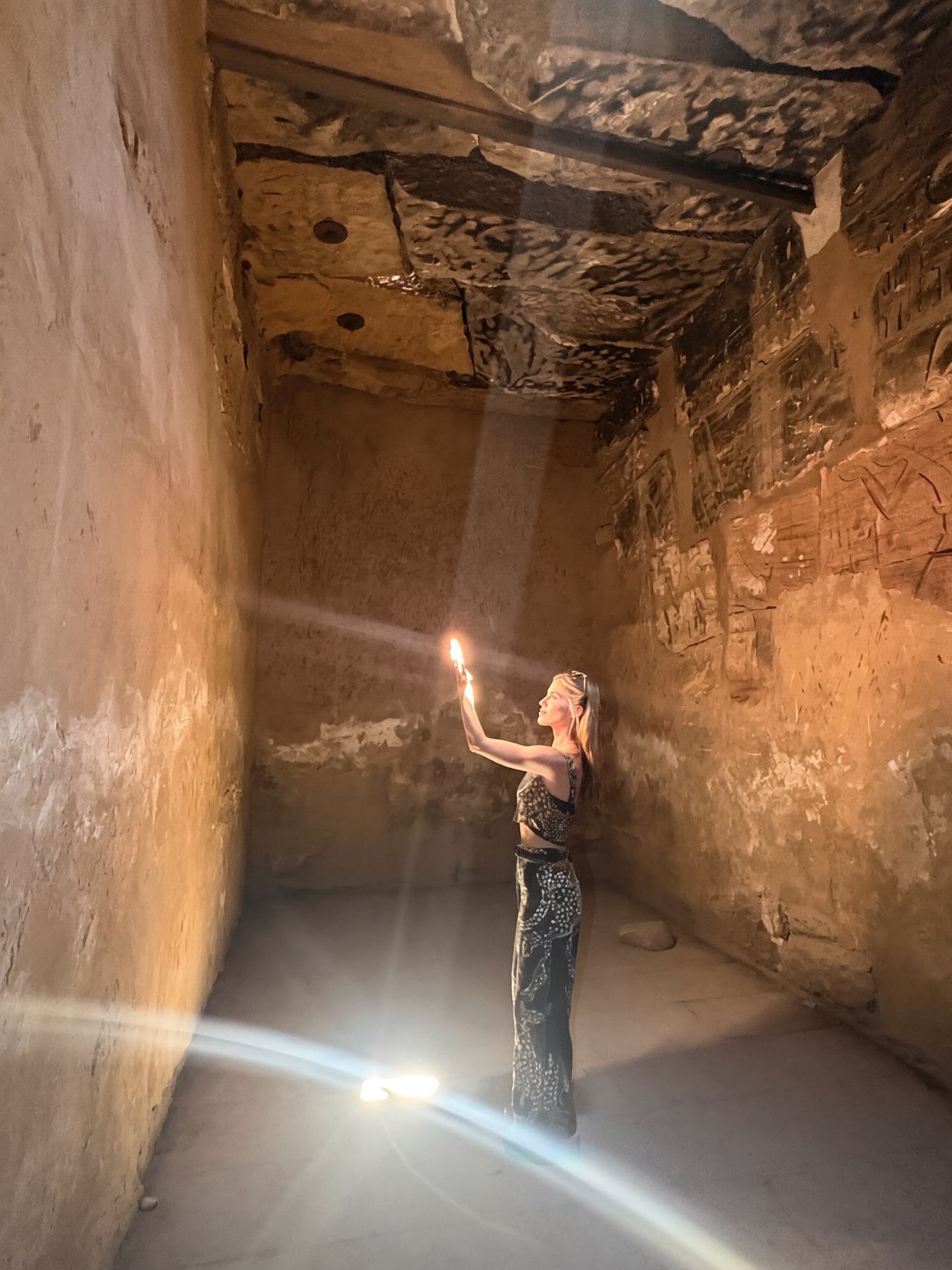 Egypt pilgrimage — inside an ancient Egyptian temple near the pyramids Rachel Neufelder holding a light inside an ancient Egyptian temple corridor in Egypt, near the Giza pyramids